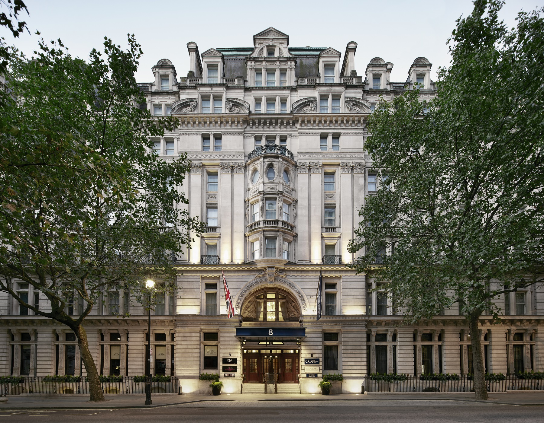 a large white building with a lit-up entrance